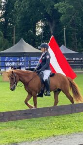 Lorraine Essl reitet mit der österreichischen Flagge